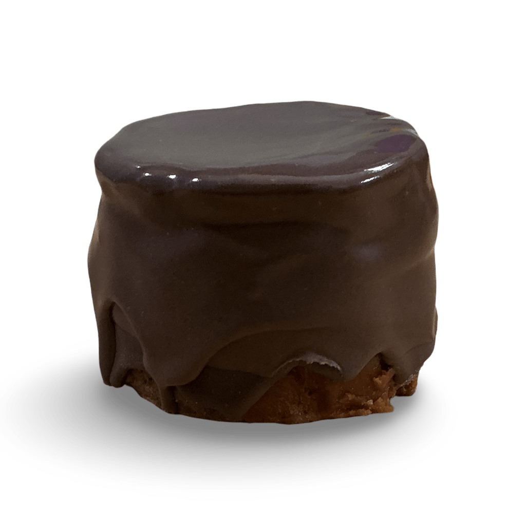 Small round chocolate ganache petit four cake with smooth dark icing on a black background.