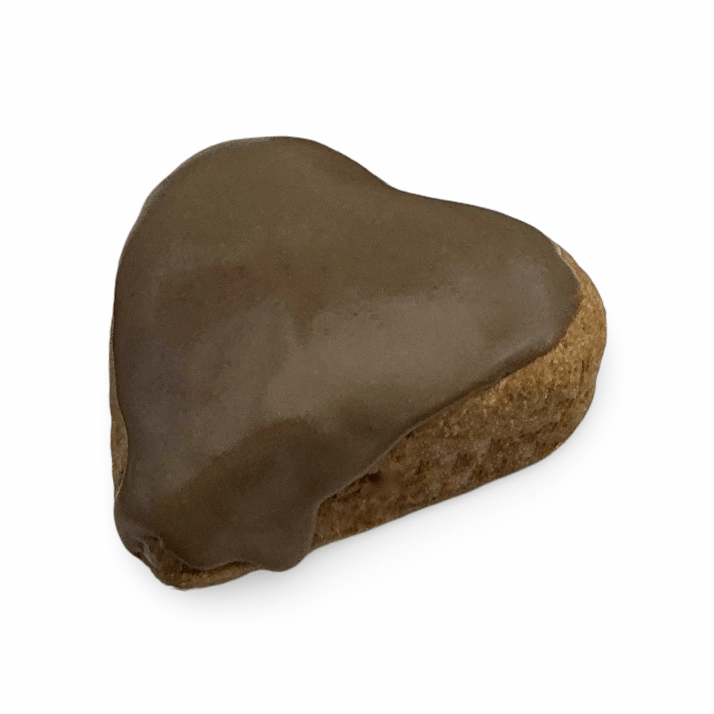 Heart-shaped gingerbread cookie topped with smooth chocolate icing against a black background.