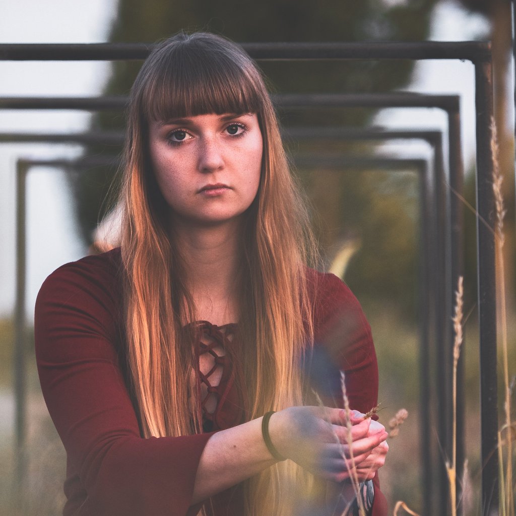 a woman in a red dress sitting under bicycle stands