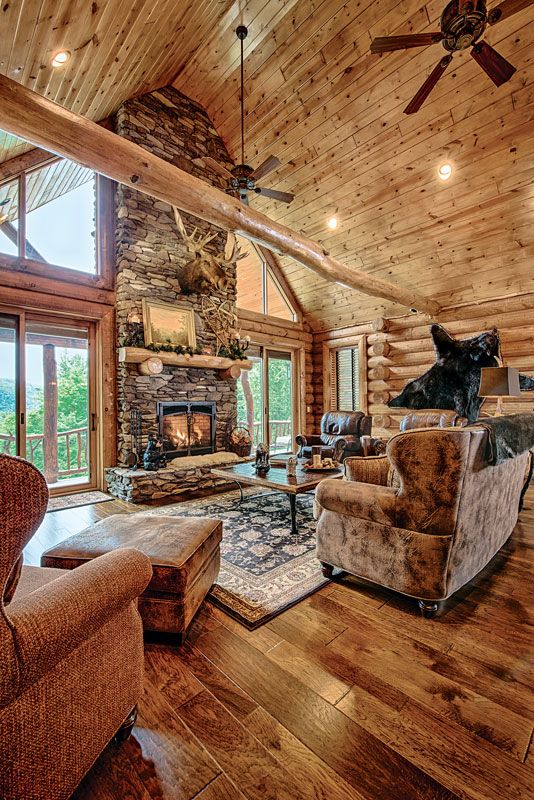 Wooden mountain cabin interior with stone fireplace and warm flooring
