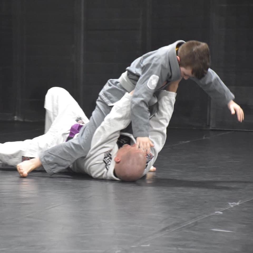 coach training child in bjj