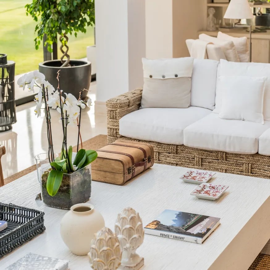 Natural-textured living area with woven sofa and garden views at Villa El Olivo, Marbella