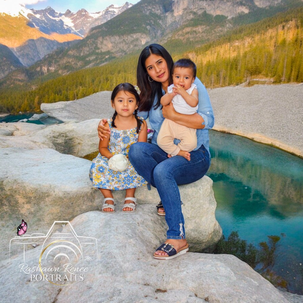 a woman sitting on a rock with her two children for a family portrtait session