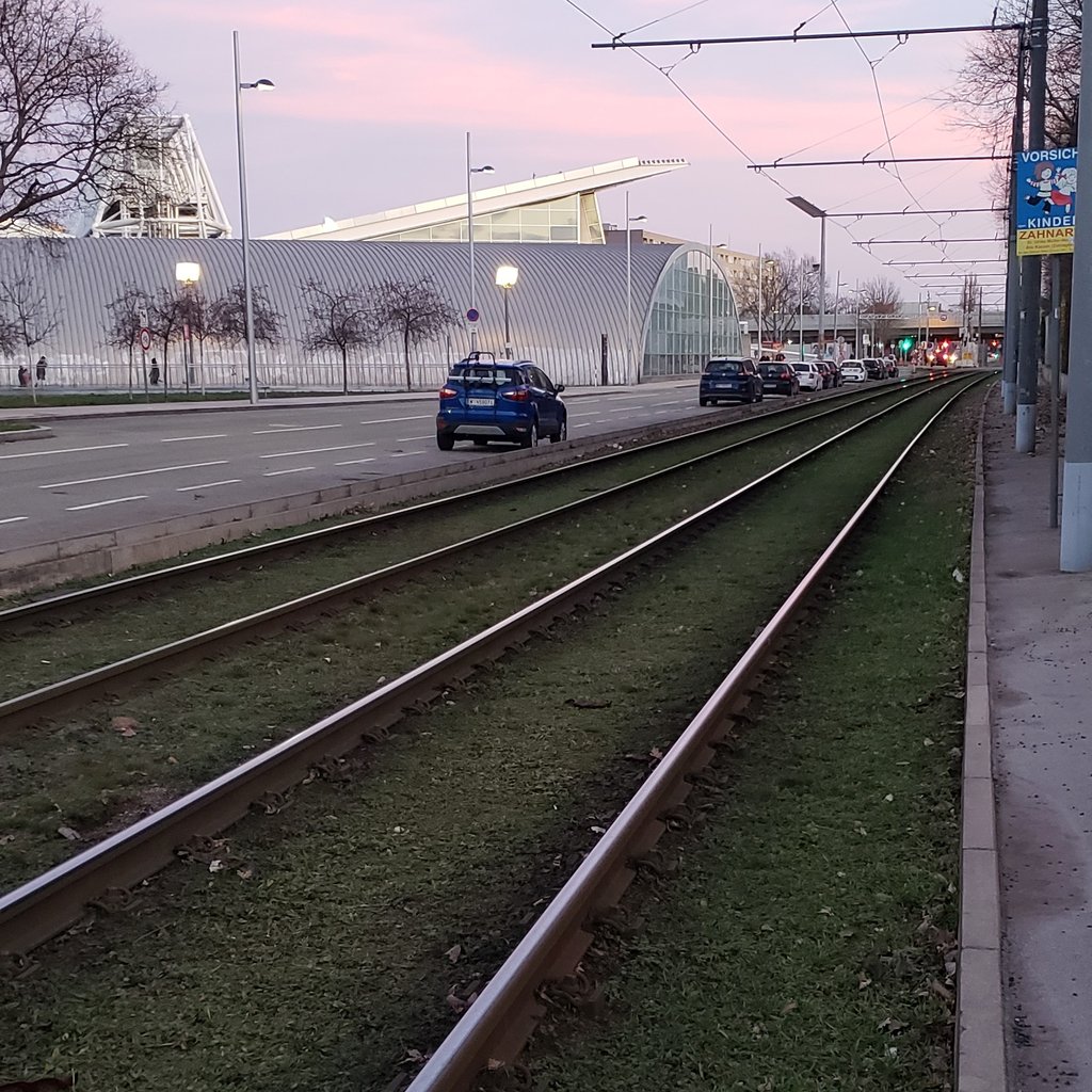Light rail train tracks next to a road