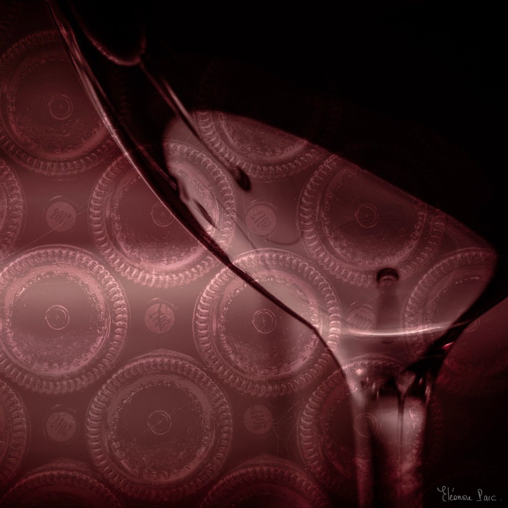 Verre de vin devant une pile de cul de bouteilles de vin en cave