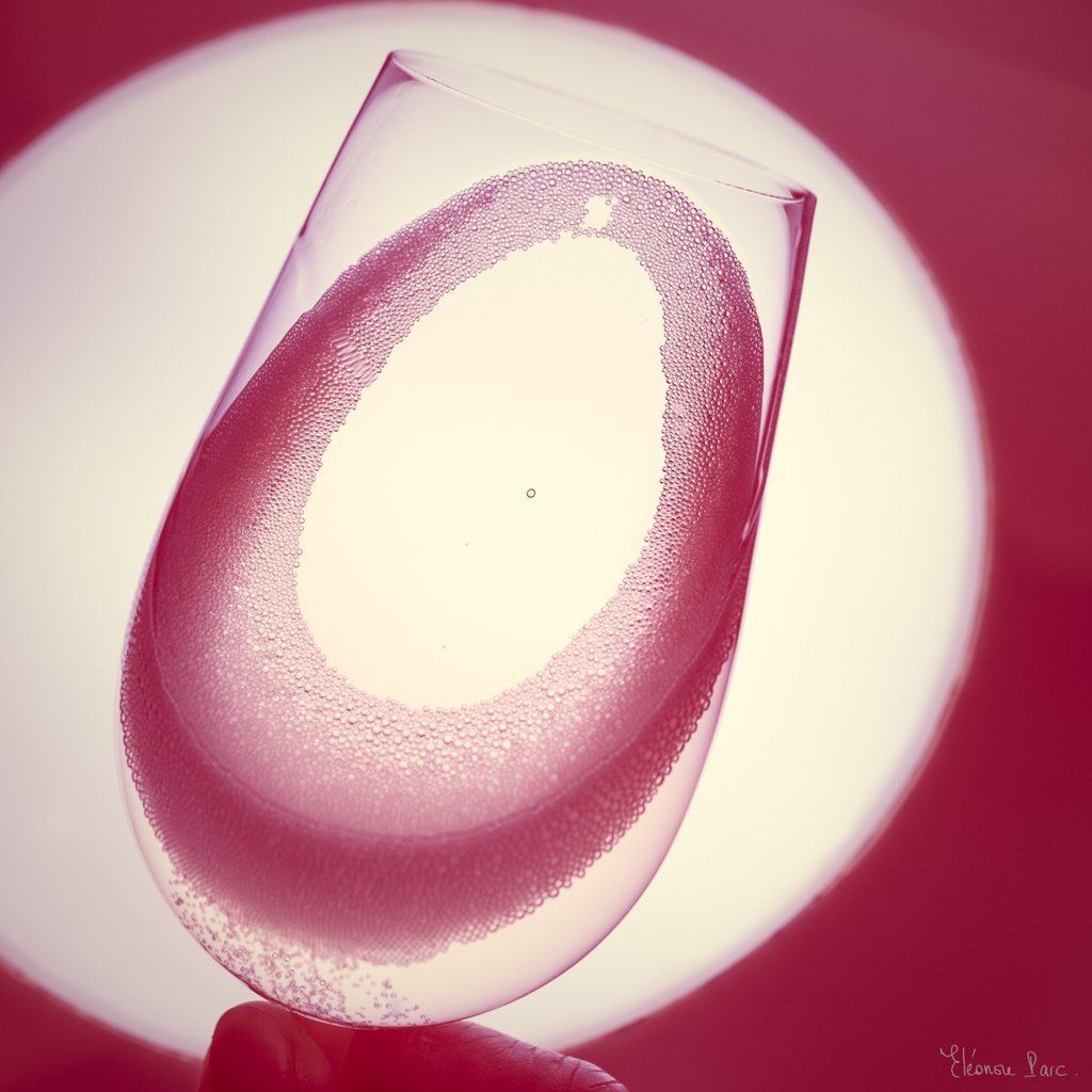 Le Vin en Rose – Ovales lumineux dans un verre de vin rosé