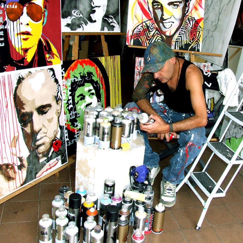 Sérgio Astral, em seu ateliê, com quadros em pop-art.