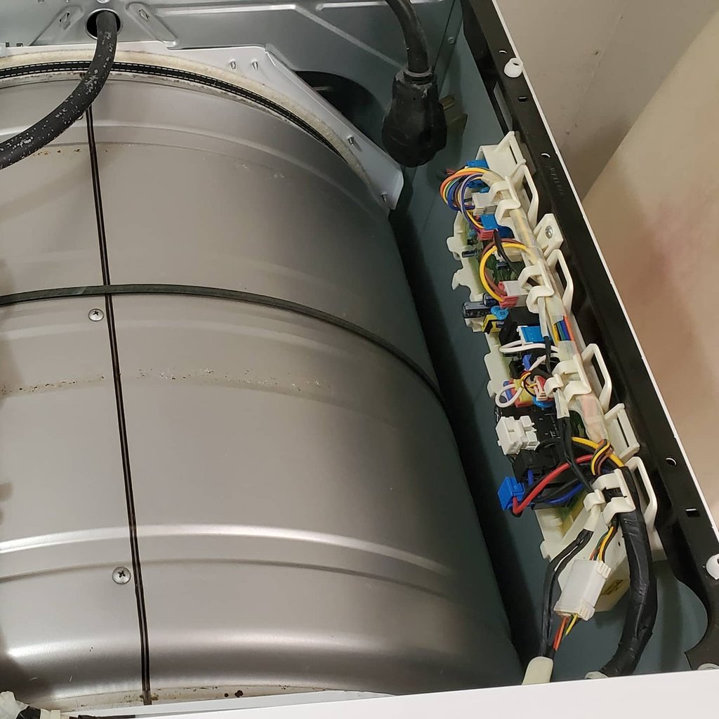 Opened dryer top revealing visible control board for repair.