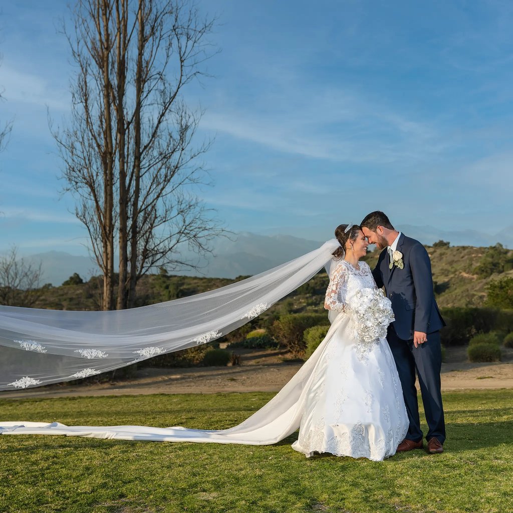 a bride and groom kissing in a field