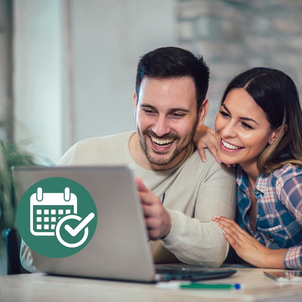 a man and woman looking at a laptop computer screen