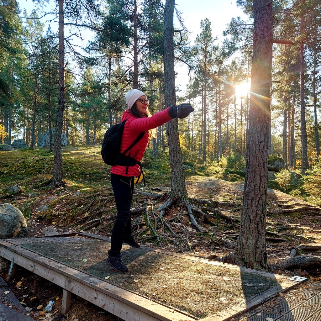 a woman in a red jacket throwing a frisbee