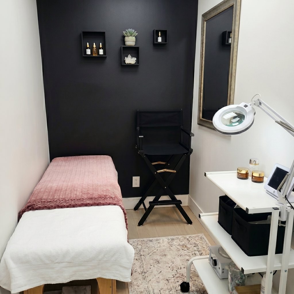 Modern medical spa treatment room with a massage table, skincare products, and professional magnifying lamp.