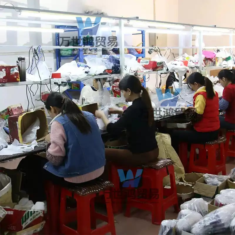 Factory workers on an assembly line packaging goods for export in a manufacturing facility.