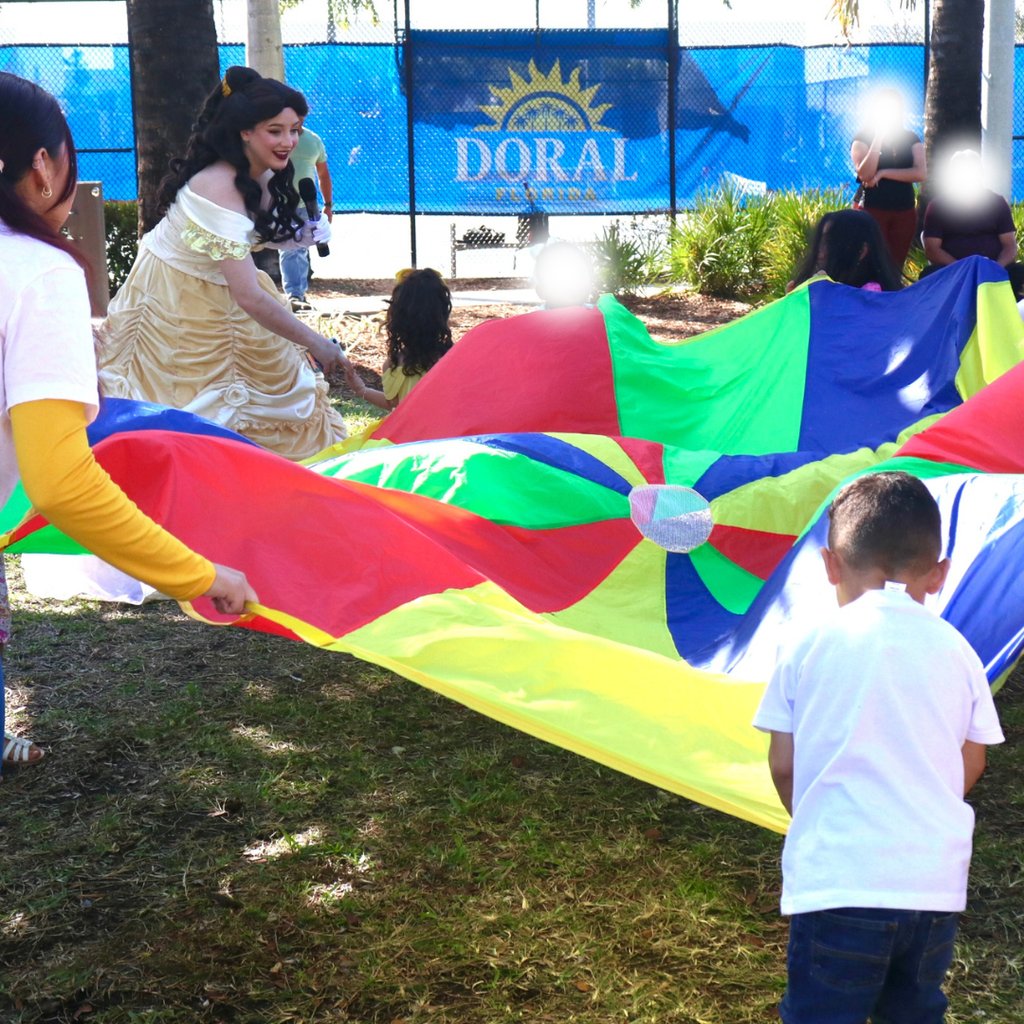 A group of kids playing parachute fun with princess Dell as the entertainer