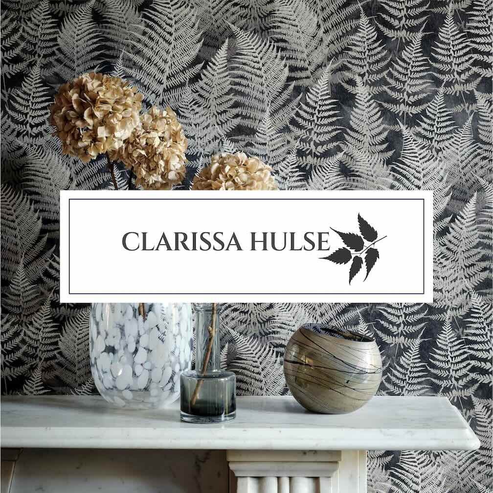 Clarissa Hulse fern wallpaper behind a marble mantel with dried hydrangeas and decorative glass vases.