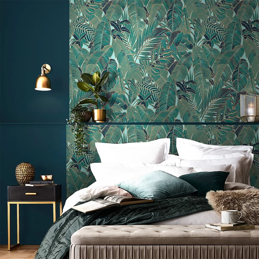 Elegant bedroom featuring tropical teal palm leaf wallpaper and luxury gold decor accents.