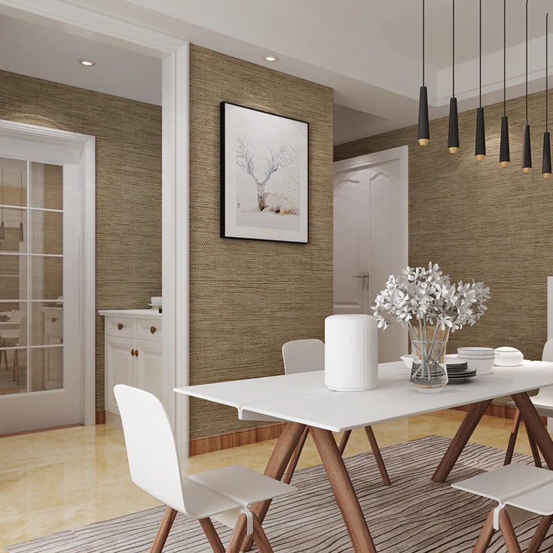 Modern dining room with brown textured wallpaper, white table, and black pendant lights.
