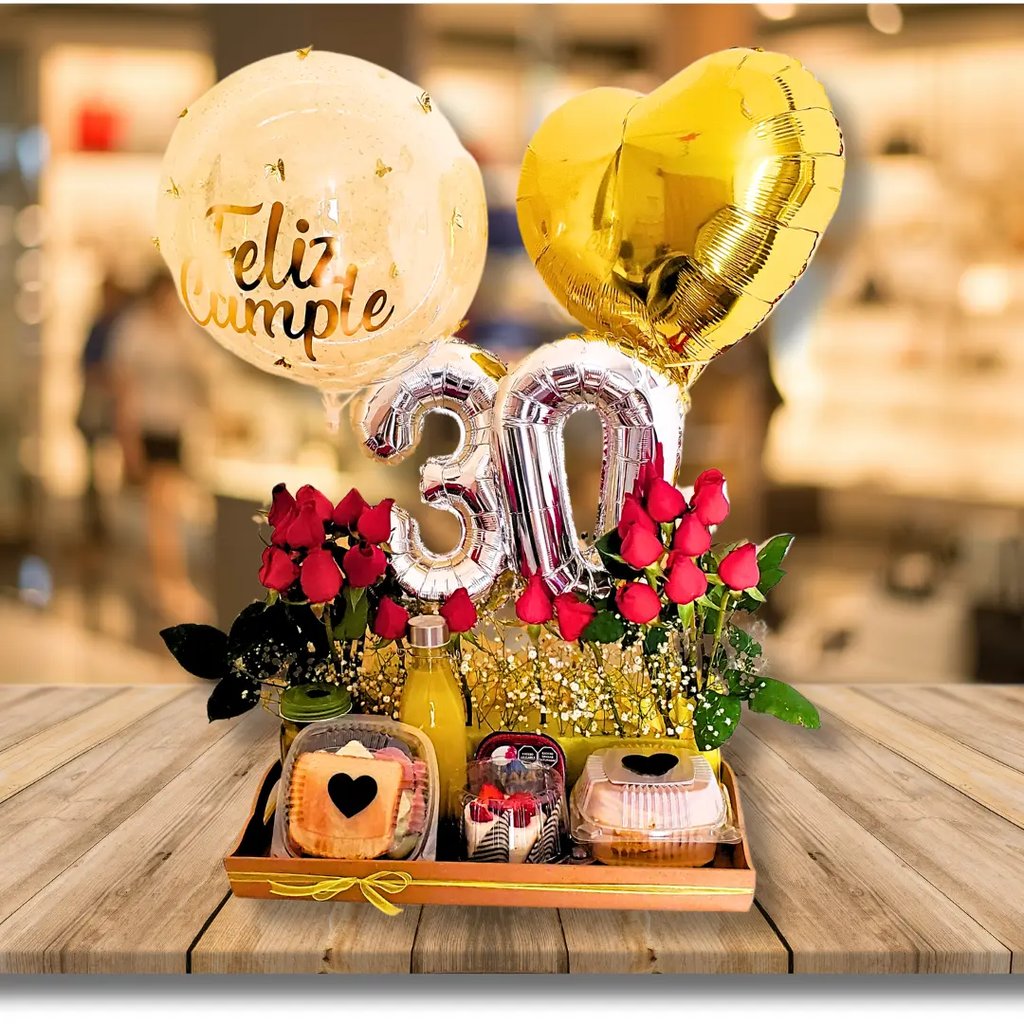 Una caja de madera llena de frutas y flores y un globo en forma de corazón.