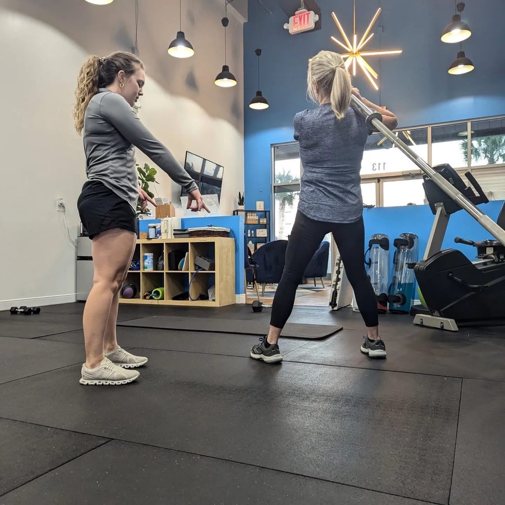 trainer instructing landmine exercise