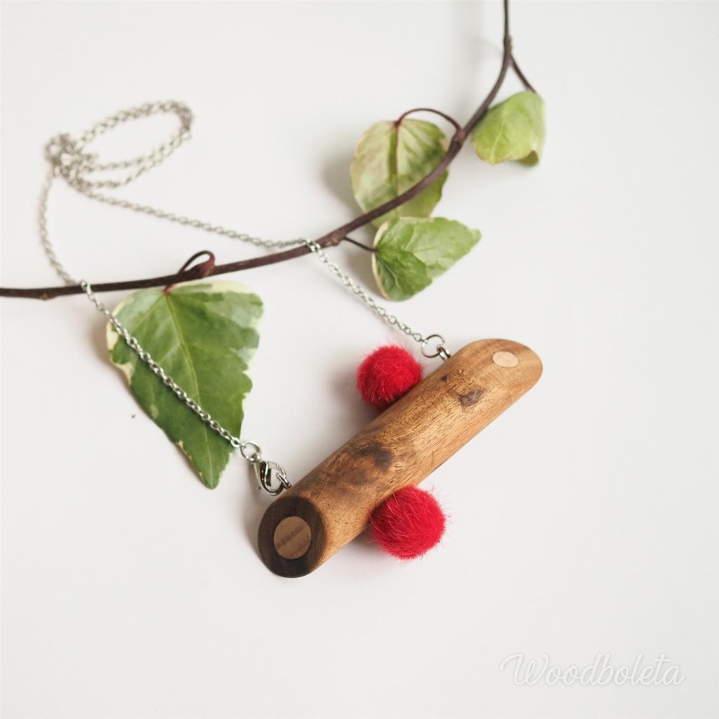 Necklace with wooden pendant and fluffy pompoms