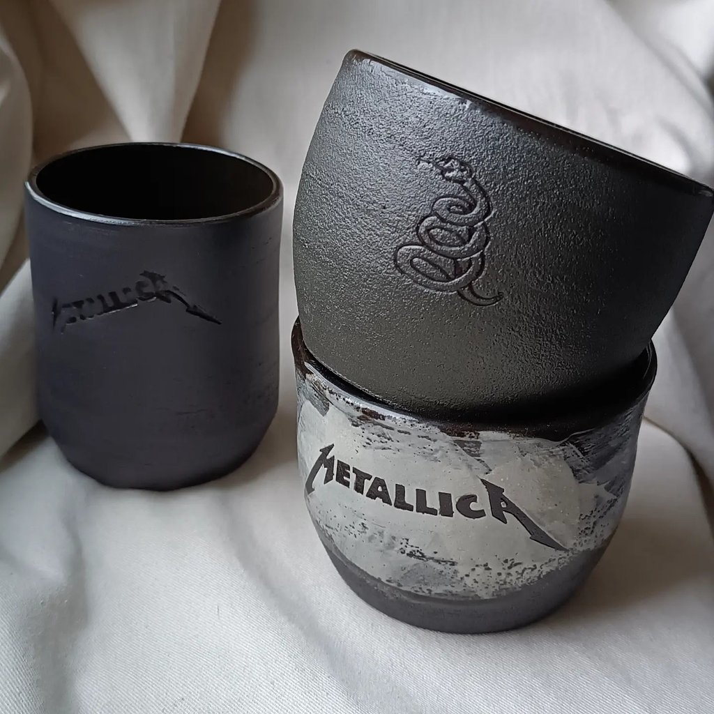 Juodi puodeliai su Metallica simbolika