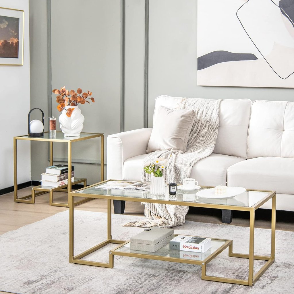 Modern glass coffee table and matching side table with gold metal frames in a contemporary living room.