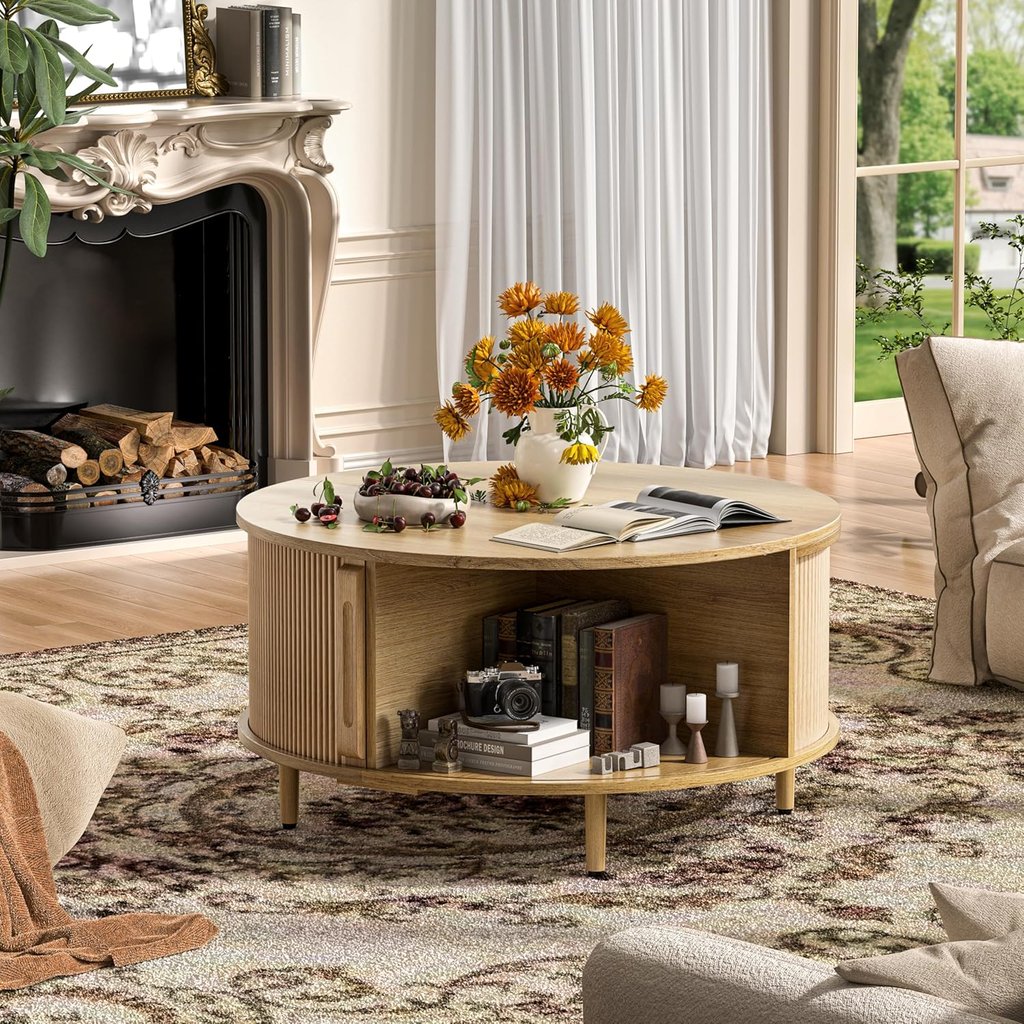 Round light wood coffee table with storage shelf in a bright living room near a fireplace.