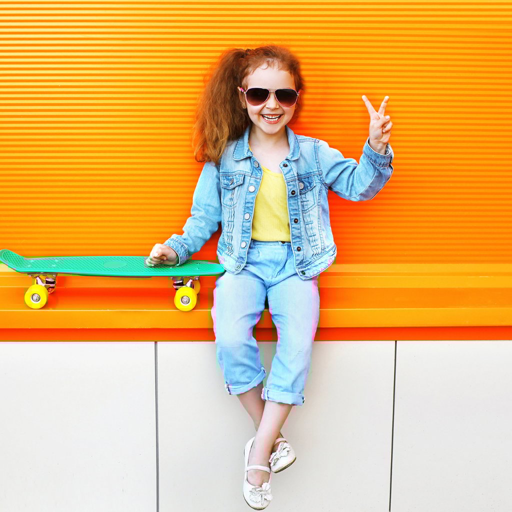 LIttle girl with stylish sunglasses holding up a peace sign