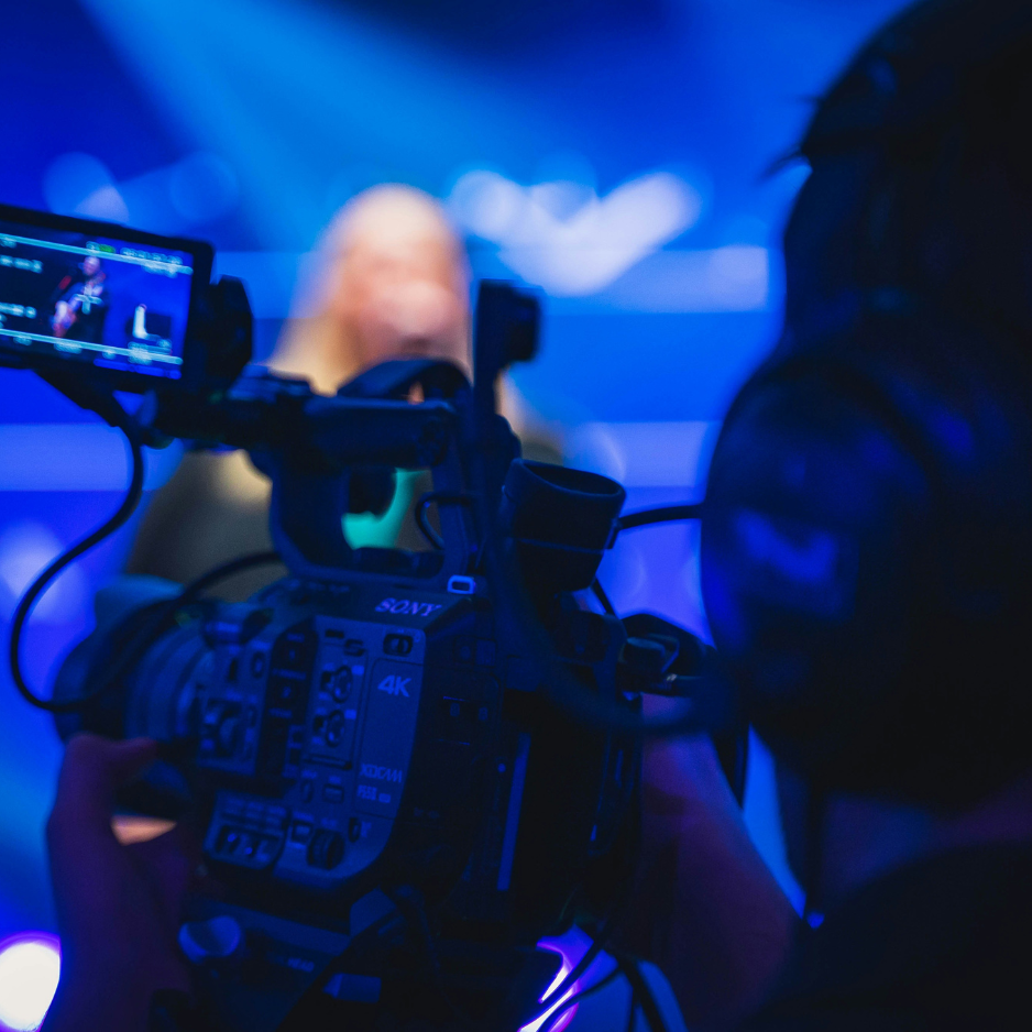 Professional videographer filming a live performance with a Sony 4K digital cinema camera.