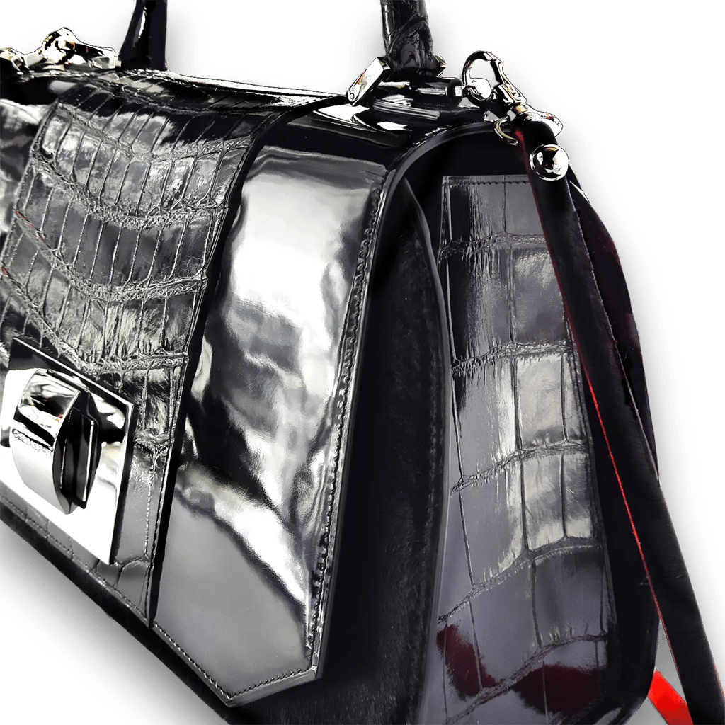 Luxury black crocodile skin handbag with shiny silver hardware and patent leather details.