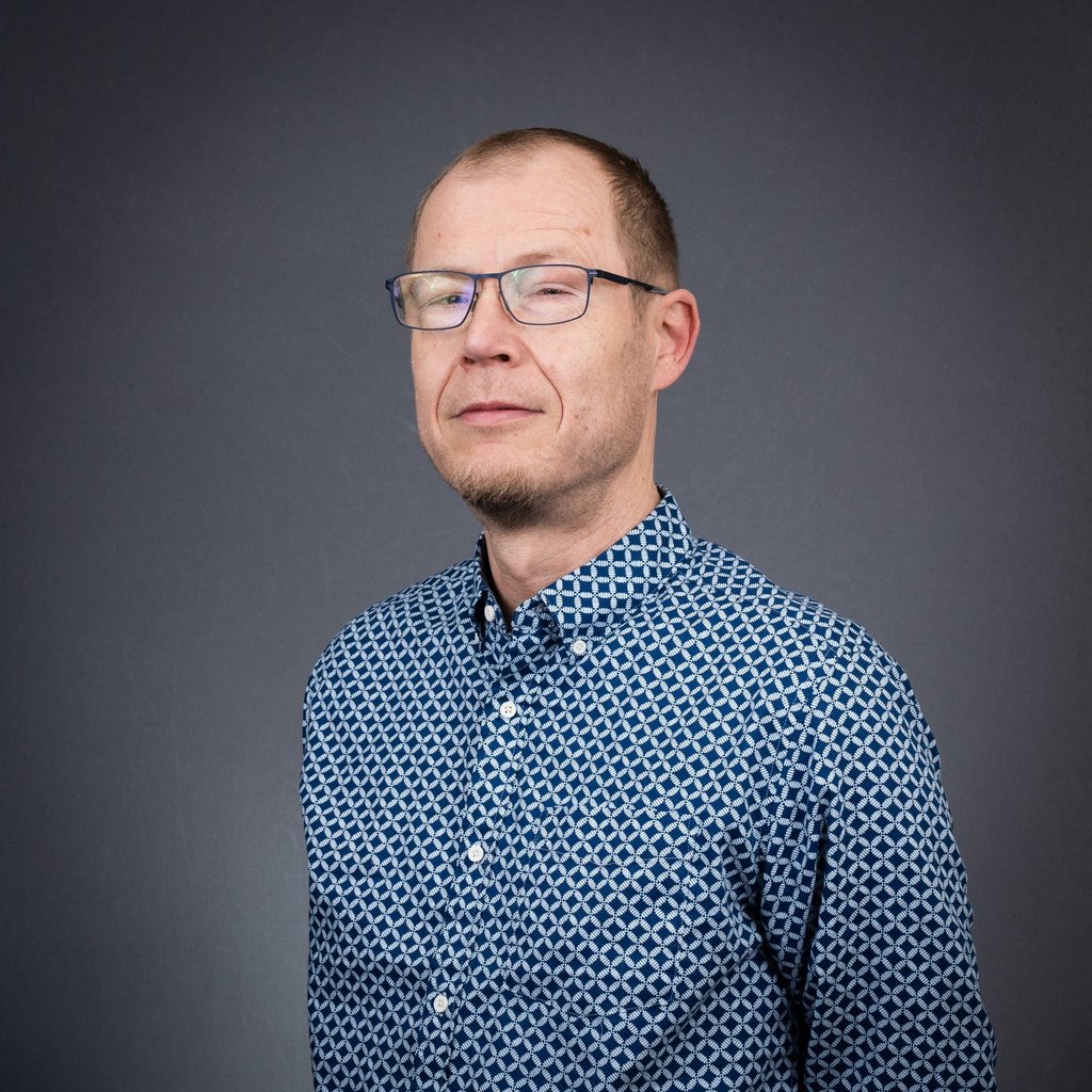 a man in a blue shirt and glasses