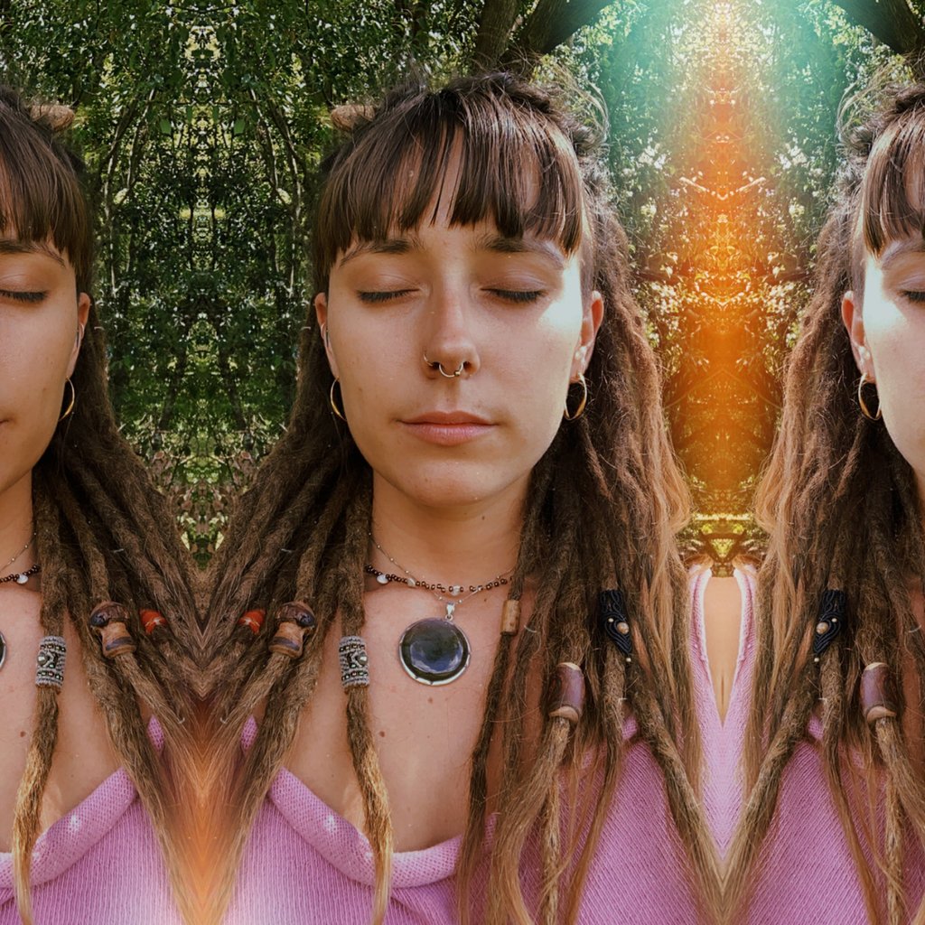 a woman with long dreadlocks and a pink shirt