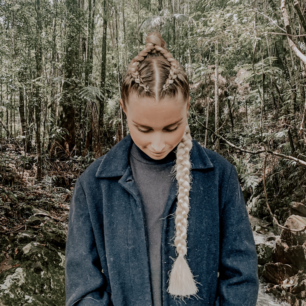 a woman with 2 corn rows into a braid plait.