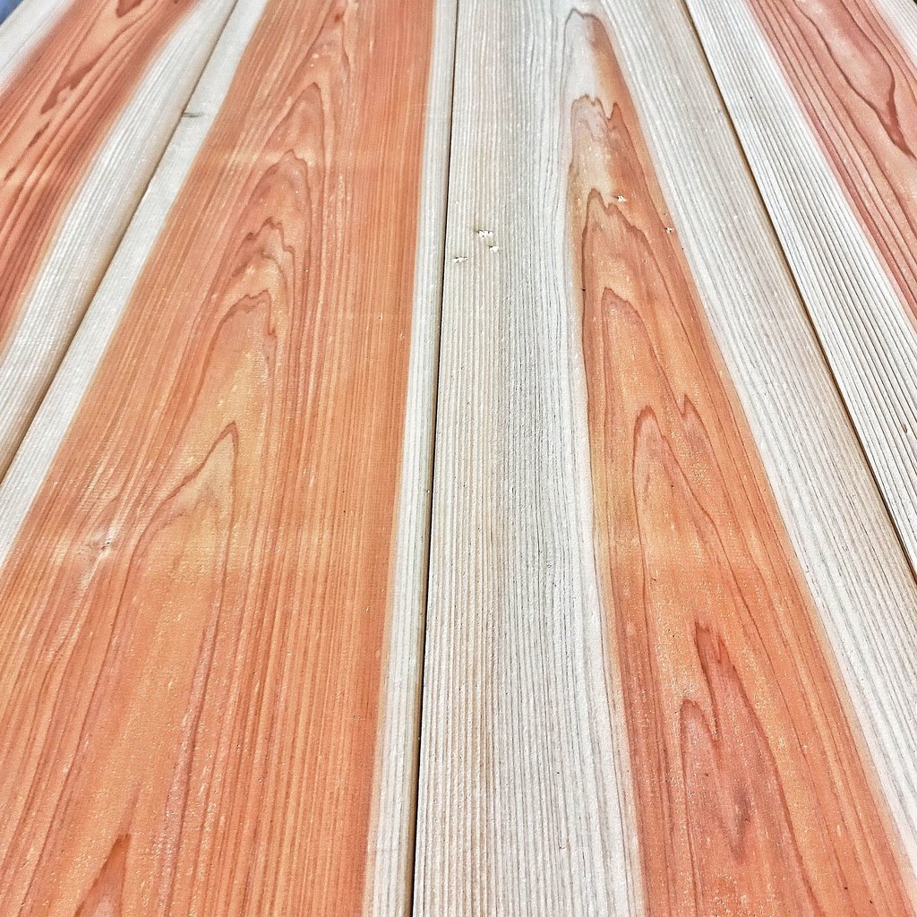 Polished sugi wood planks with natural orange grain patterns and vertical texture for flooring.
