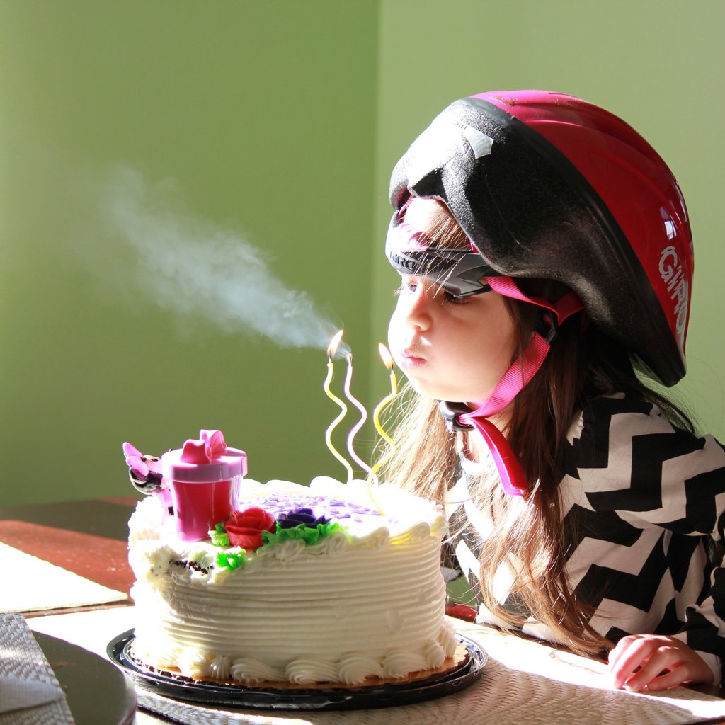 a young girl blowing out birthday candles