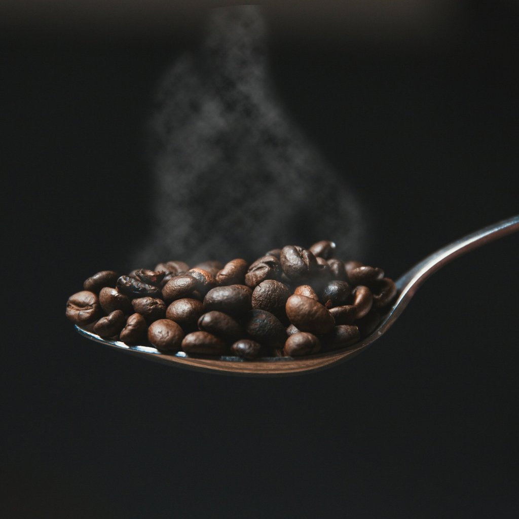 A spoon with freshly roasted coffee beans with fresh smoke visible