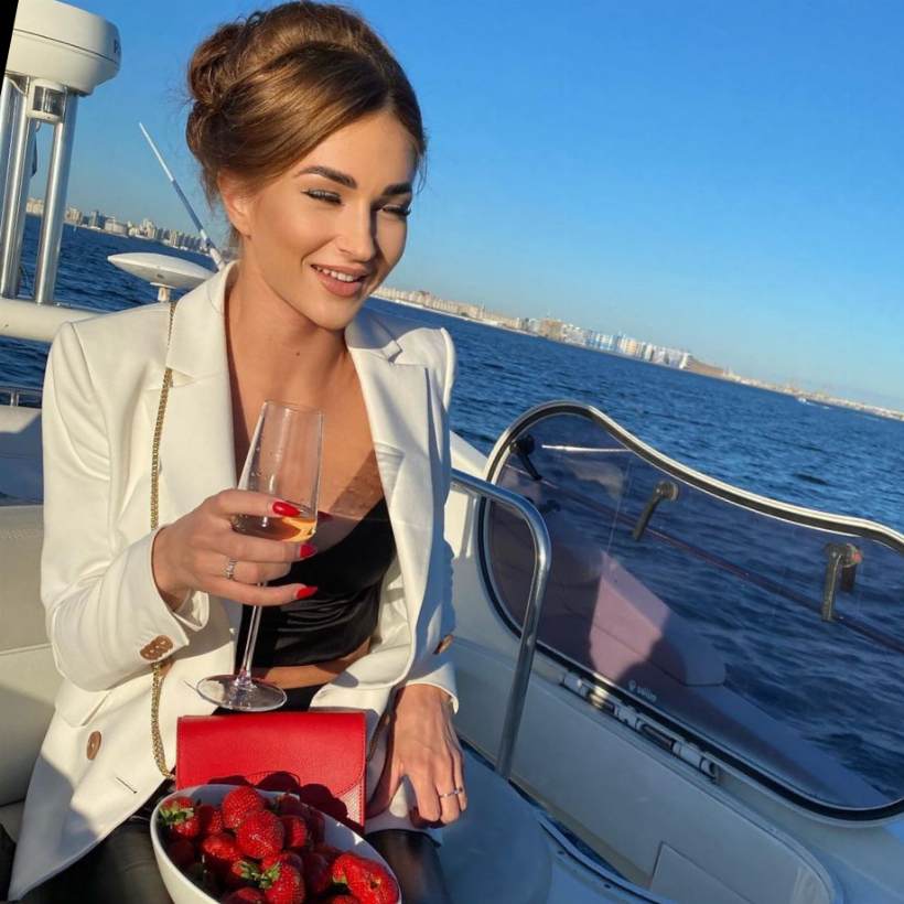 femme sur bateau tient un verre de vin