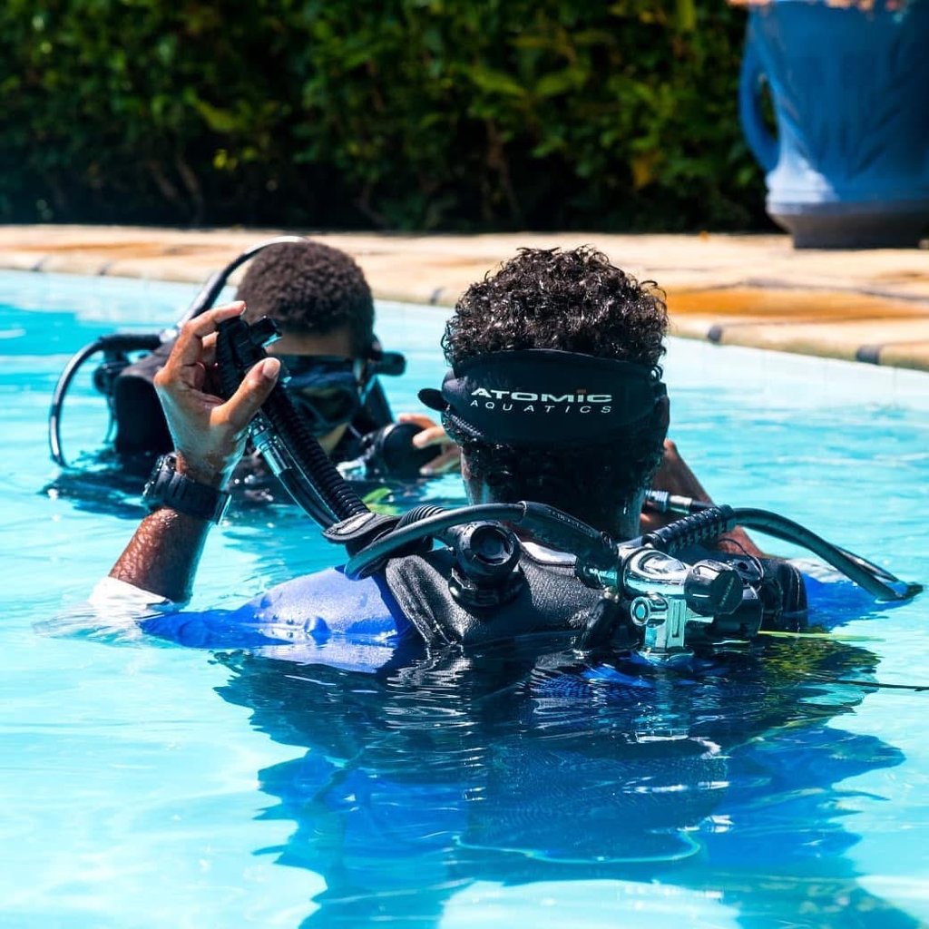 two people in scuba diving suits in a pool