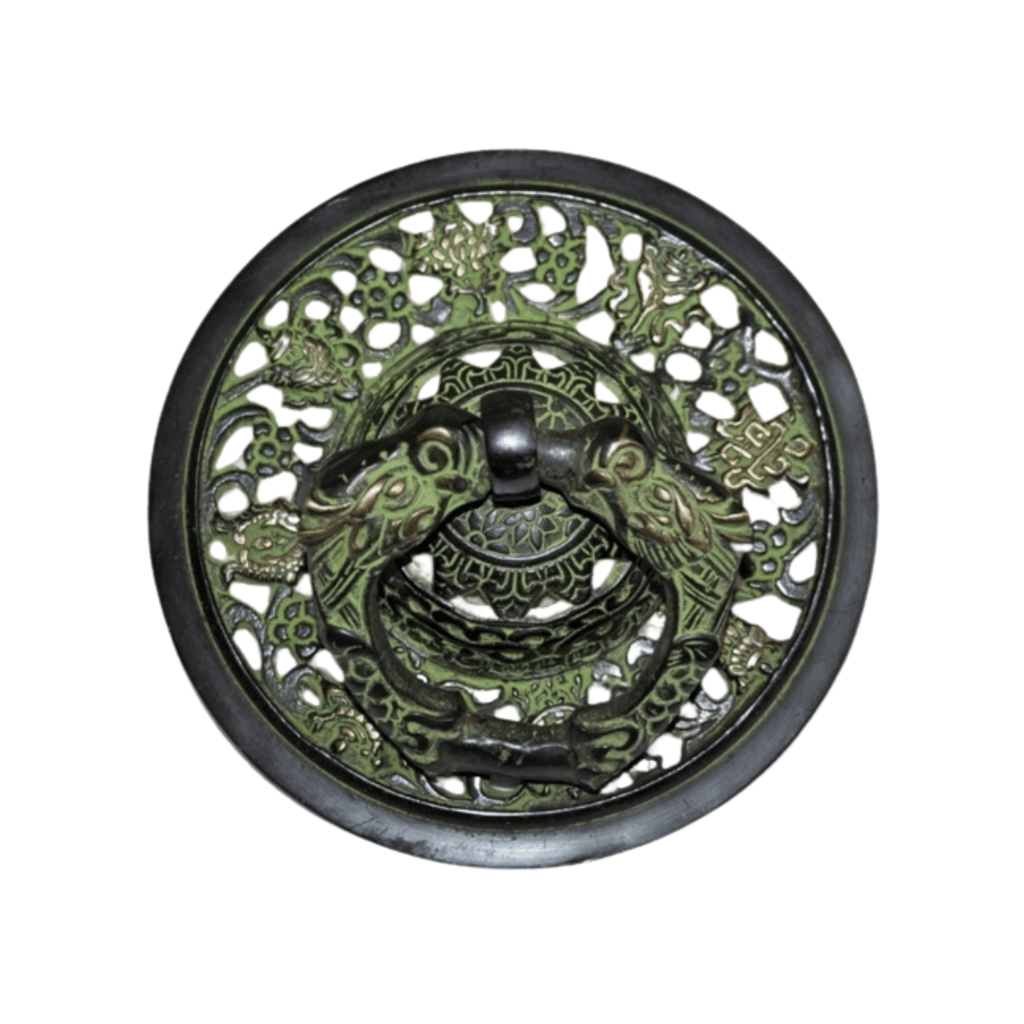 a decorative metal plate with a green dragonfly