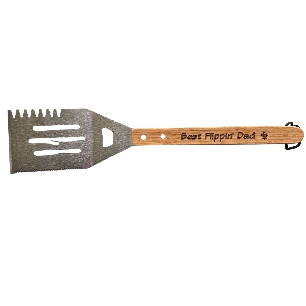A outdoor grill spatula that has best flippin' dad engraved on the handle