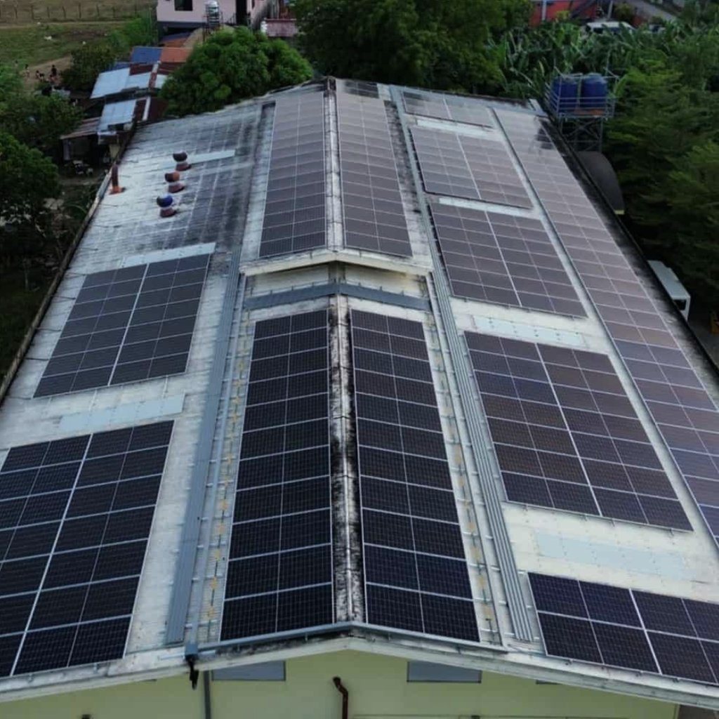 Aerial view of a commercial building rooftop with an installed solar panel system for renewable energy.