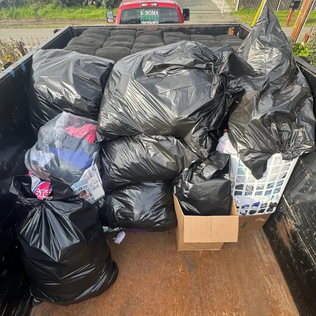 pile of trash bags and a futon in a trailer
