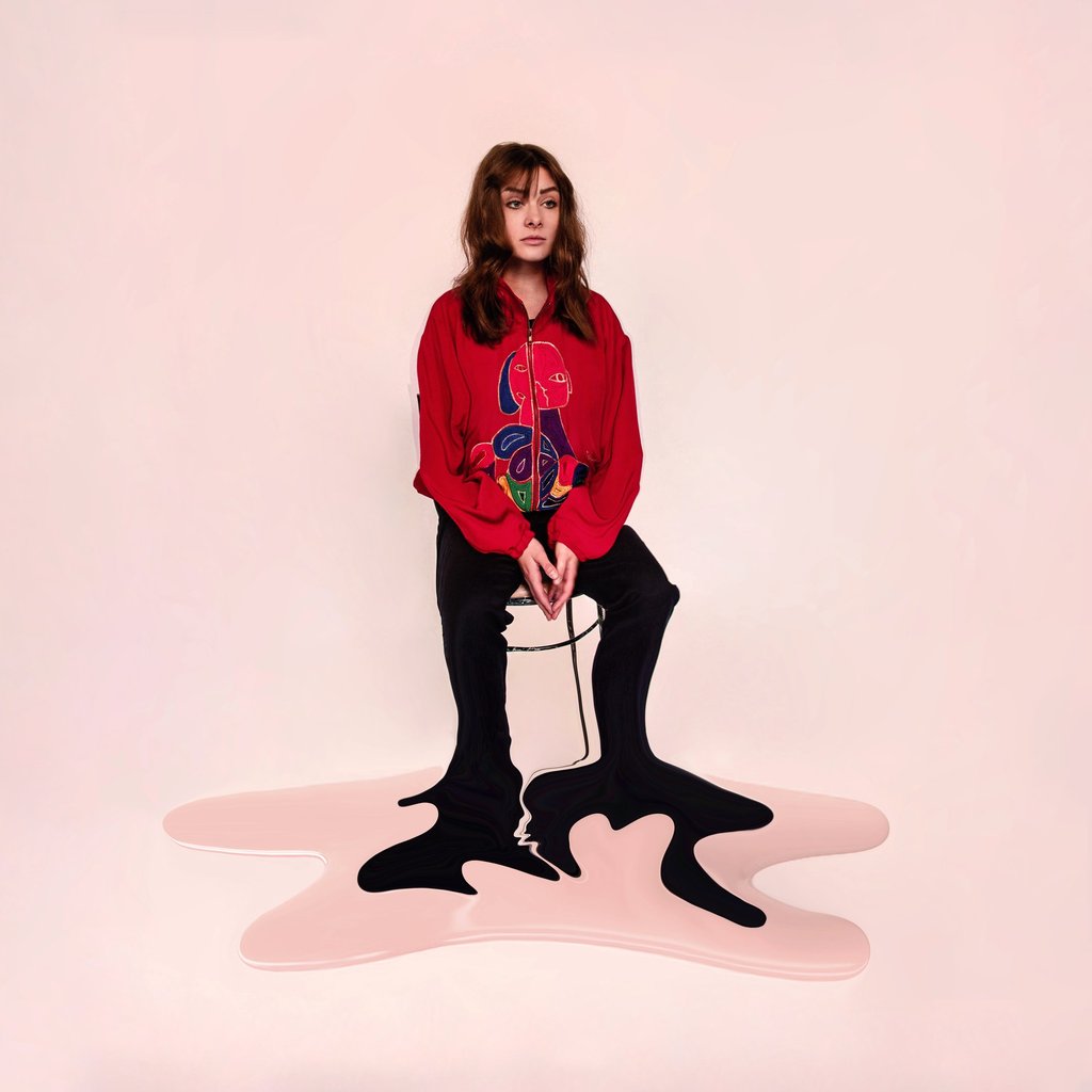 Surreal fashion portrait of a woman in a red jacket with legs melting into a pink floor puddle.