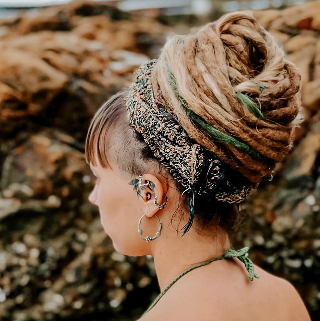 a woman and a dreadlock bun at the beach