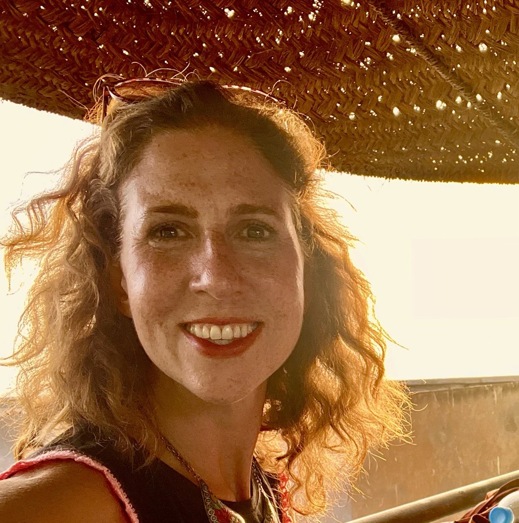 Kat Kojic, a smiling woman with shoulder length curly hair