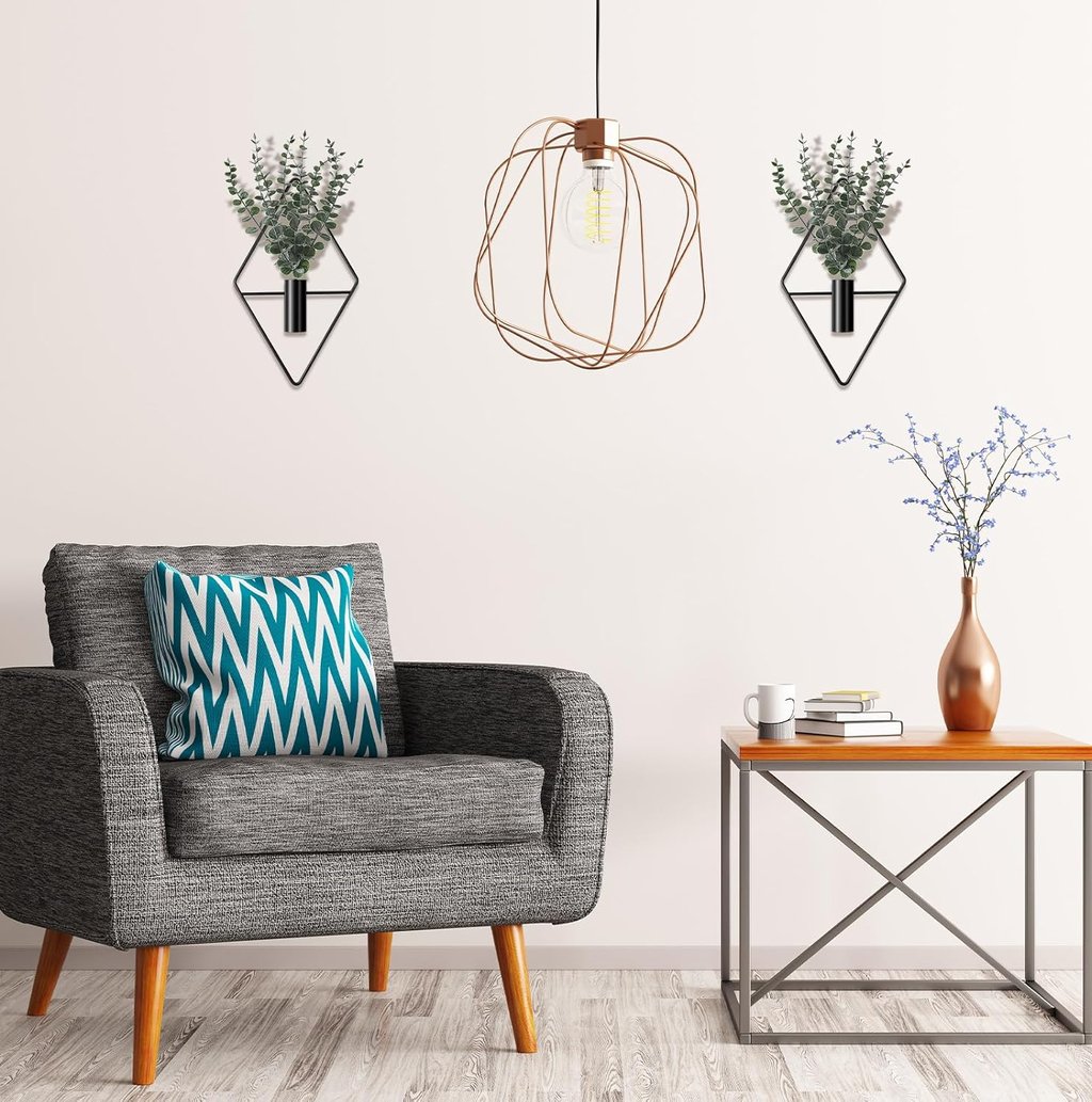 Modern living room featuring geometric wall planters with eucalyptus and a copper wire pendant light.