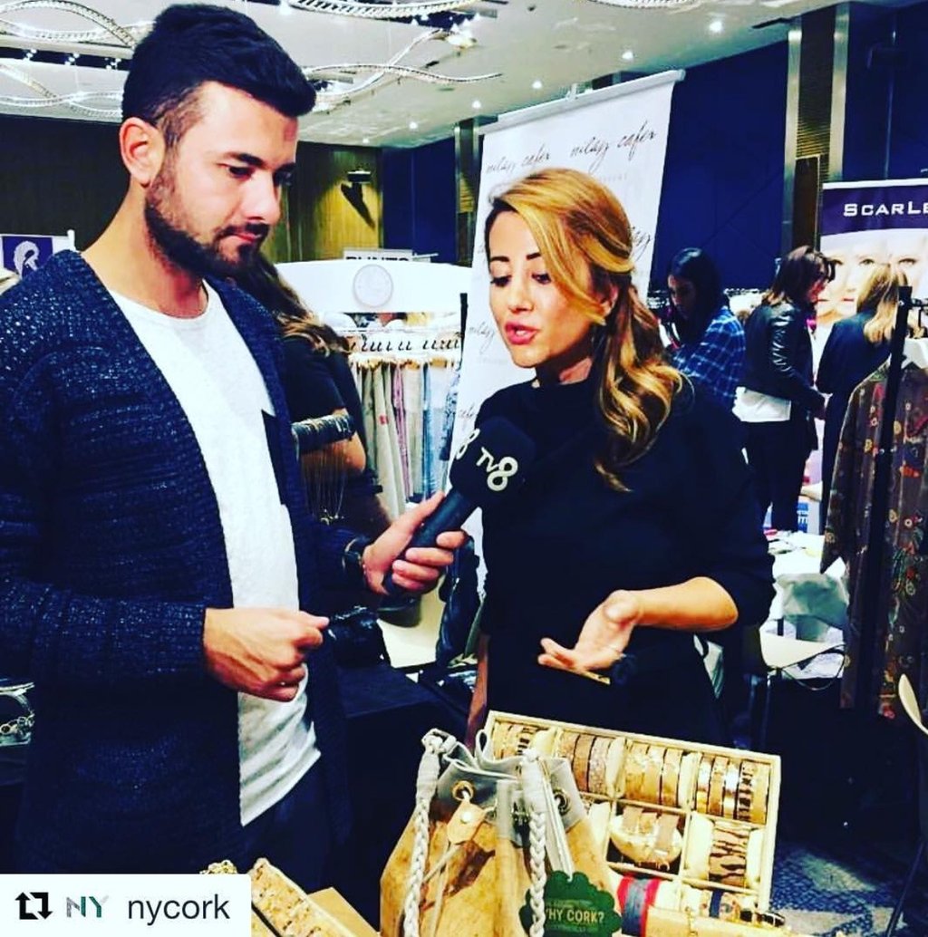 TV8 reporter interviewing Neri Cetin about eco-friendly cork accessories at a boutique trade show.