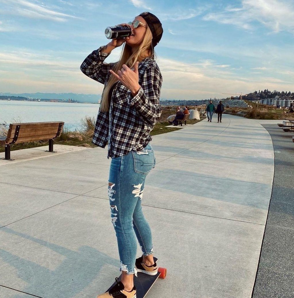 femme en train de boire debout sur un skateboard