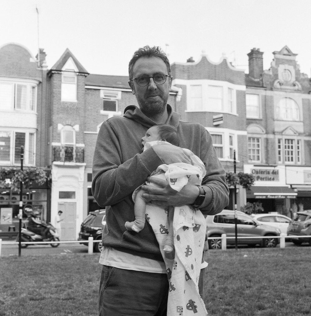 Man in London holding his newborn baby