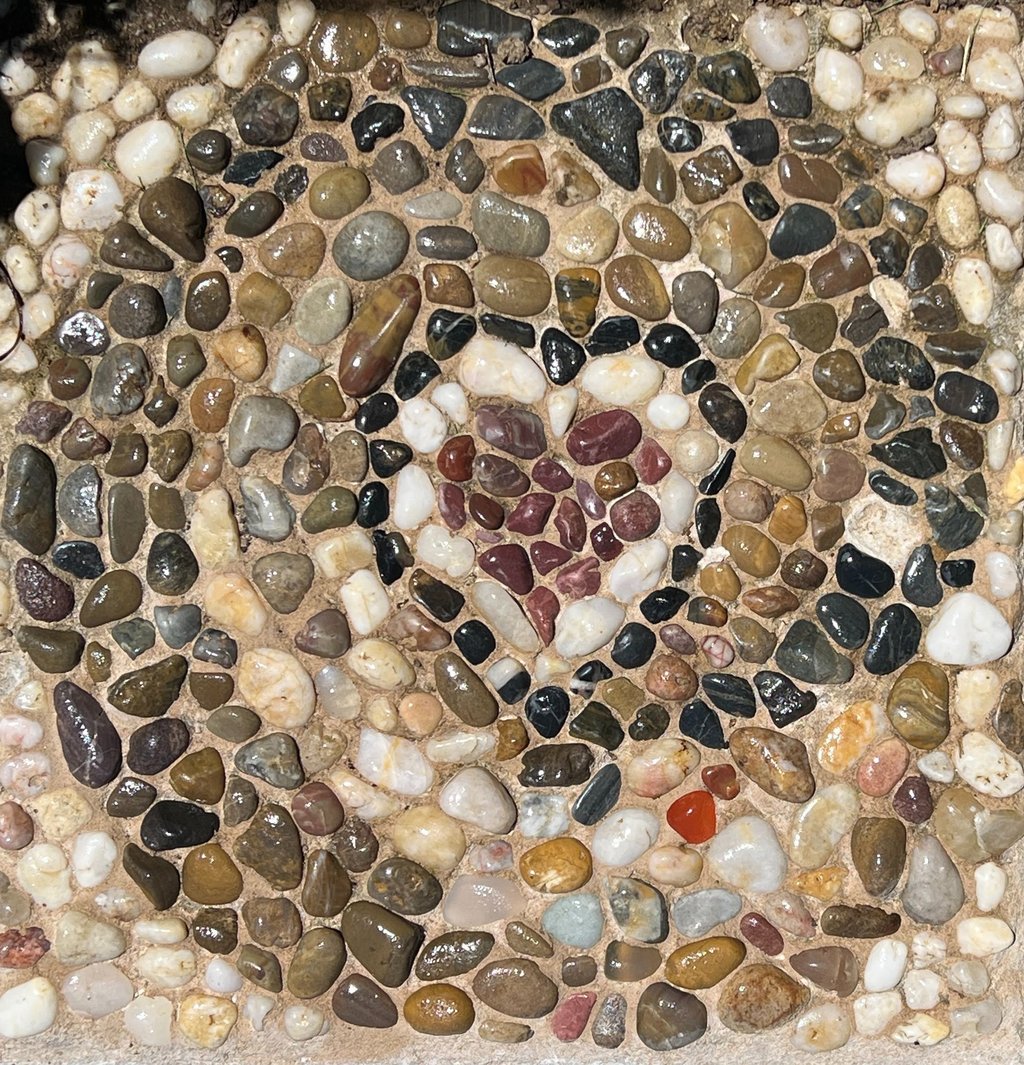 Pathway to the Heart: Handcrafted river stone mosaic stepping stone by artist Julie Curson.